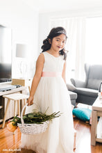 Load image into Gallery viewer, Flower girl wearing Grace Vneck ivory dress with basket of flowers
