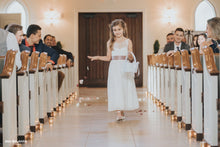 Load image into Gallery viewer, Beautiful flower girl walking in Roselle lace flower girl dress with open V-neck on the back with a basket