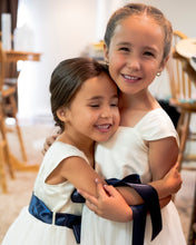 Load image into Gallery viewer, Annabelle dress Ana Balahan Two cute hugging flower girls in comfortable Annabelle dresses with navy sashes 
