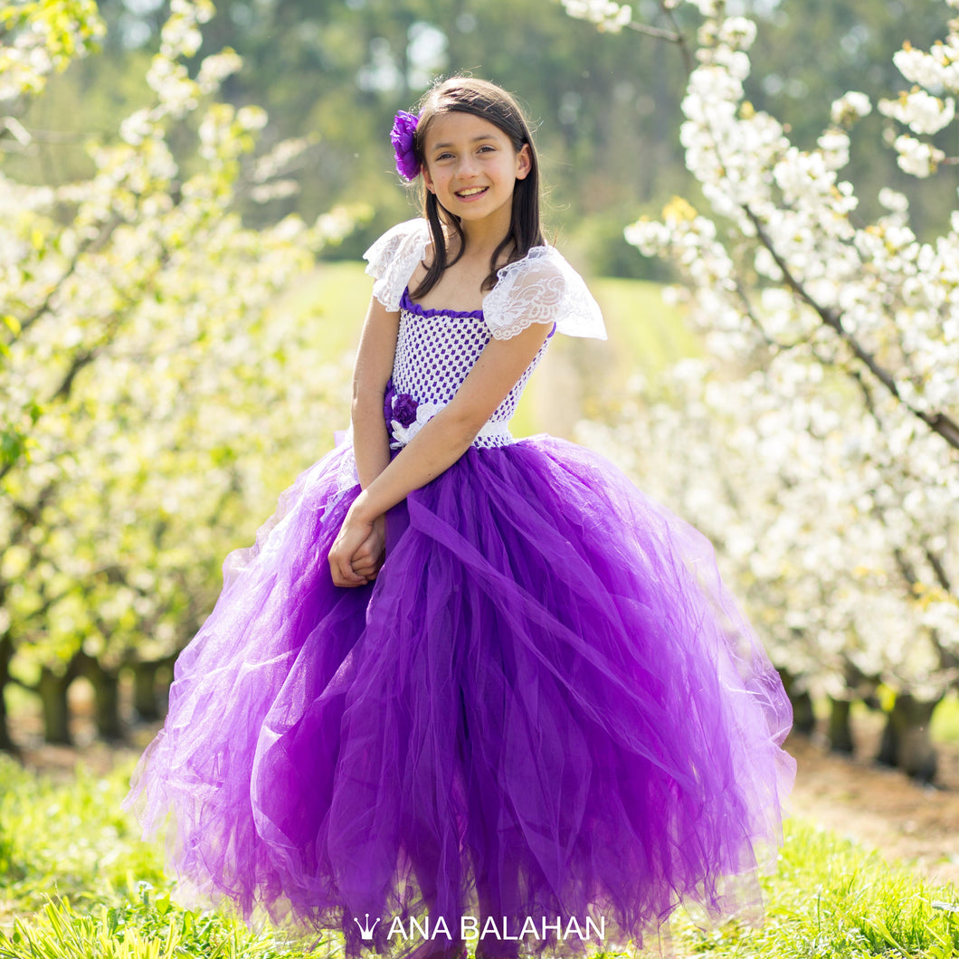 Girl in magnificent Jacaranda flower girl dress amongst blossoming cherry trees
